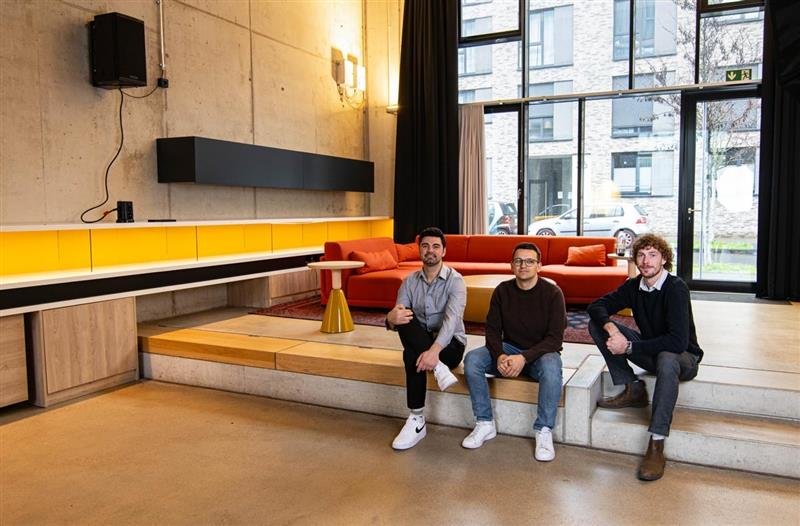 Drei Männer sitzen auf einer Stufe mitten im Raum in einem Marketing Büro