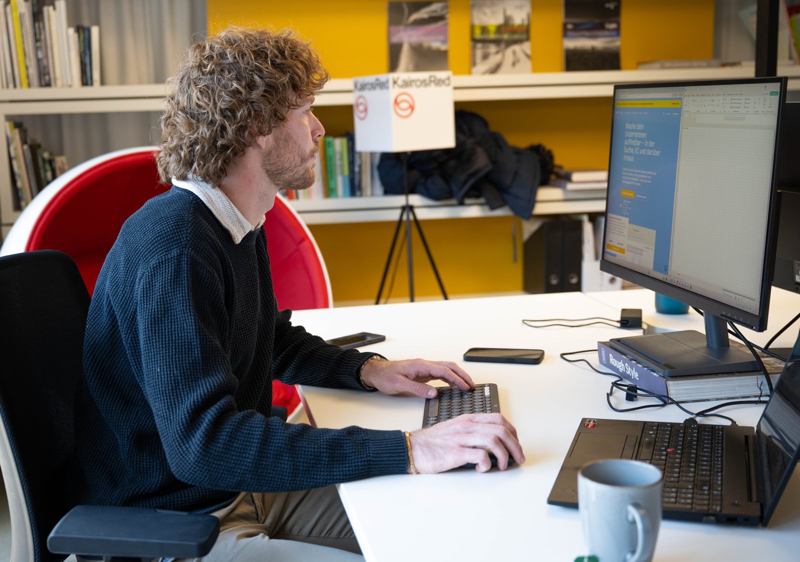 Mann arbeitet in einem Büro am Laptop