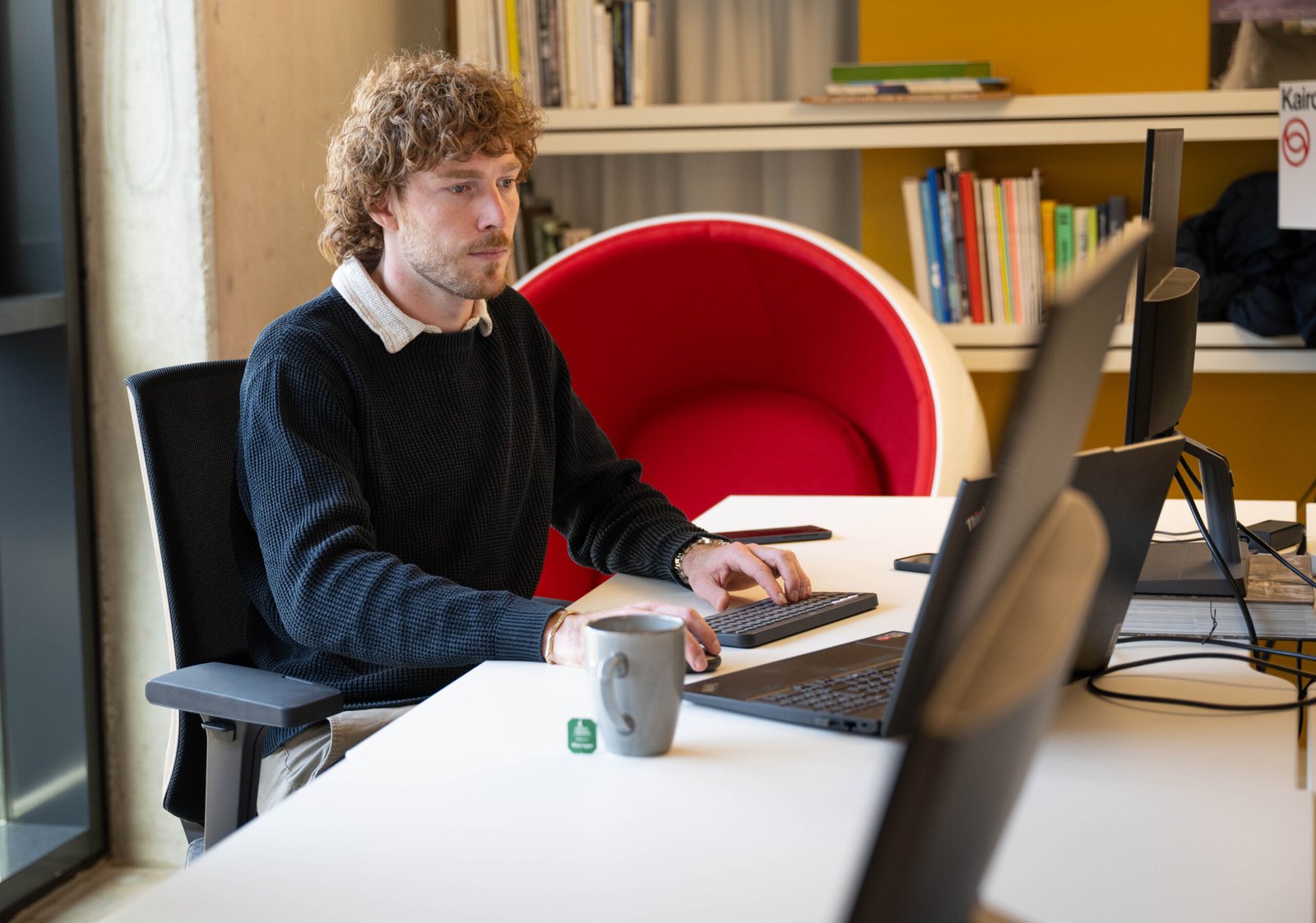 Mann arbeitet in einem Marketingbüro am Bildschirm