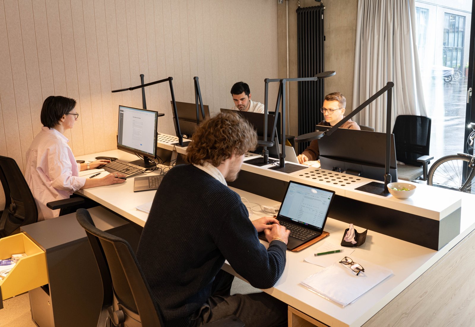 Vier Menschen arbeiten in einem Online Markting Büro an Laptops.